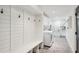 Bright laundry room with white cabinets, shiplap accent wall, washer and dryer and herringbone tile floor at 6175 Weatherly Dr, Sandy Springs, GA 30328