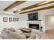 Cozy living room with white brick fireplace, wood beams, and comfortable sofa at 6175 Weatherly Dr, Sandy Springs, GA 30328