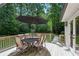 A dining table with an umbrella sits on the wooden back deck, perfect for outdoor dining and relaxation at 6175 Weatherly Nw Dr, Sandy Springs, GA 30328