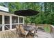 Wooden back deck features a dining table with chairs and an umbrella for outdoor entertaining at 6175 Weatherly Nw Dr, Sandy Springs, GA 30328