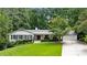 Charming white ranch-style home with well-manicured front yard and inviting curb appeal at 6175 Weatherly Nw Dr, Sandy Springs, GA 30328