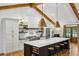 Bright kitchen with an island, stainless appliances, vaulted ceiling, wood beams, and stylish pendant lighting at 6175 Weatherly Nw Dr, Sandy Springs, GA 30328