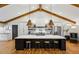 Stunning kitchen featuring a large island with seating, modern stainless appliances, and a stylish vaulted ceiling with beams at 6175 Weatherly Nw Dr, Sandy Springs, GA 30328