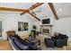 Bright sun room featuring vaulted ceilings, wood beams, a stone fireplace and modern furniture at 6175 Weatherly Nw Dr, Sandy Springs, GA 30328