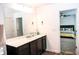 Bathroom featuring dual sinks, a large mirror, and a view into the bedroom at 15 Regal Ln, Covington, GA 30016