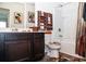 Bathroom showcasing dark wood cabinets, a bathtub with shower, and decorative touches at 15 Regal Ln, Covington, GA 30016