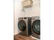 Modern laundry room with wood-look flooring, washer, and dryer at 15 Regal Ln, Covington, GA 30016