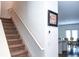 Carpeted staircase featuring a white handrail leading to the upper level of the home at 15 Regal Ln, Covington, GA 30016