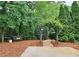 Serene backyard retreat with a bench, a brick walkway, and verdant greenery for relaxation at 215 Settindown Ct, Roswell, GA 30075