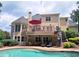 A picturesque backyard view showcases a multi-level deck, a swimming pool, and lush landscaping for outdoor enjoyment at 215 Settindown Ct, Roswell, GA 30075