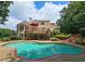 Beautiful backyard with a large pool, deck, lounge area, and mature landscaping, perfect for outdoor living and entertaining at 215 Settindown Ct, Roswell, GA 30075