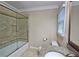 Well-lit bathroom featuring a bathtub with tiled walls, modern fixtures, and tile flooring at 215 Settindown Ct, Roswell, GA 30075
