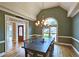 Formal dining room boasts elegant chandelier, beautiful trim detail, and large windows for natural light at 215 Settindown Ct, Roswell, GA 30075