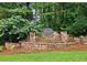 Stone monument entrance with a 'Foxhall' sign surrounded by meticulously kept landscaping creating a welcoming community presence at 215 Settindown Ct, Roswell, GA 30075