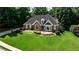 Beautiful brick home featuring manicured lawn and mature landscaping, showcasing curb appeal at 215 Settindown Ct, Roswell, GA 30075