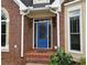 Elegant blue front door with decorative glass and sidelights, brick entryway at 215 Settindown Ct, Roswell, GA 30075