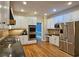Bright kitchen with stainless steel appliances, granite countertops, and white cabinets at 215 Settindown Ct, Roswell, GA 30075