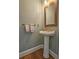 Powder room featuring a pedestal sink and wood-framed mirror at 215 Settindown Ct, Roswell, GA 30075