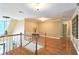 Upstairs hallway with railing overlooking foyer, hardwood floors and neutral paint throughout at 215 Settindown Ct, Roswell, GA 30075