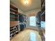 Large walk-in closet featuring custom built-in shelving, plenty of storage space, and natural light at 215 Settindown Ct, Roswell, GA 30075