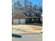 Charming two-story brick home featuring an attached two-car garage and manicured lawn on a sunny day at 2208 Ginger Lake Ne Dr, Conyers, GA 30013