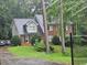 Charming two-story home with a brick facade, lush landscaping, and a driveway leading up to the residence at 423 Orchards Walk, Stone Mountain, GA 30087