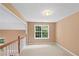 Bright landing area features neutral carpeting and ample natural light from the window at 504 Bradford Park Ct, Loganville, GA 30052