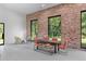 Bright dining area with exposed brick wall, modern table and chairs, and views of the lush outdoors at 538 Main St, Palmetto, GA 30268