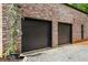 Two-car garage with black garage doors and a tidy gravel surrounding at 538 Main St, Palmetto, GA 30268