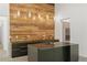 Kitchen featuring a black island with a sleek faucet and wood accent wall with pendant lighting at 538 Main St, Palmetto, GA 30268