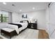 Bright bedroom with white walls, wood floors, and a comfortable bed with stylish black-and-white accents at 107 Barrington Hills Dr, Atlanta, GA 30350