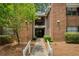 Brick condo building featuring a gated entrance, second-floor balcony, and mature landscaping at 107 Barrington Hills Dr, Atlanta, GA 30350