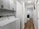 Functional laundry area with modern appliances, crisp white cabinetry, wood floors, and convenient built-ins at 107 Barrington Hills Dr, Atlanta, GA 30350
