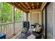 Inviting outdoor patio featuring comfortable seating, a grill, and a view of the surrounding trees at 107 Barrington Hills Dr, Atlanta, GA 30350