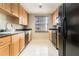 Galley kitchen with wood cabinets, black appliances, and a bright window for ample natural light at 195 14Th Ne St # 1501, Atlanta, GA 30309