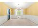 Formal dining room with yellow walls, white wainscoting, chandelier, and a large window at 2117 Chestnut Hill Circle Cir, Decatur, GA 30032