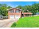 Two-story brick home with a well-manicured lawn, two-car garage, and covered porch at 2117 Chestnut Hill Circle Cir, Decatur, GA 30032
