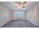 This bedroom has gray carpet and a bay window with white trim. It has a ceiling fan and closet at 446 Jaywood Dr, Stone Mountain, GA 30083