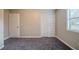 The bedroom has gray carpet, a window, a double-door closet, and a door at 446 Jaywood Dr, Stone Mountain, GA 30083