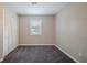 This bedroom has gray carpet, a window, and a double-door closet at 446 Jaywood Dr, Stone Mountain, GA 30083