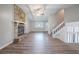 Spacious living room with a stone fireplace, ceiling fan, wood floors, and stairs to the upper level at 446 Jaywood Dr, Stone Mountain, GA 30083