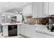 Modern kitchen featuring white cabinets, marble countertops, stainless steel sink, and black appliances at 719 Mcgill Park Ne Ave, Atlanta, GA 30312