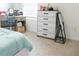 Bright bedroom featuring a white dresser, desk, and a comfortable blue bed at 2159 Redfern Rd, Dacula, GA 30019