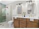 Modern bathroom featuring dual sink vanity, wooden cabinets, glass shower with gold hardware at 6456 Wright Ne Rd, Atlanta, GA 30328