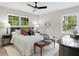 Comfortable bedroom with neutral decor, a ceiling fan, bench, and plenty of natural light at 6456 Wright Ne Rd, Atlanta, GA 30328