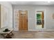 Bright entryway with a wood-look front door, adjacent sidelight, and a bench with hat at 6456 Wright Ne Rd, Atlanta, GA 30328