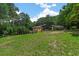 Spacious backyard with a modern home, lush trees, and a sprawling lawn at 6456 Wright Ne Rd, Atlanta, GA 30328
