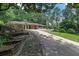 A single-story house with a front-facing driveway, a carport, and mature trees in the background at 6456 Wright Ne Rd, Atlanta, GA 30328