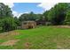 Back exterior view of a modern home with spacious yard and abundant trees in the background at 6456 Wright Ne Rd, Atlanta, GA 30328