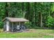 Charming backyard shed with a cozy porch, set amidst lush greenery and trees at 6456 Wright Ne Rd, Atlanta, GA 30328